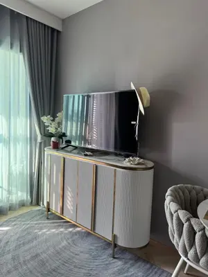 a living room with a flat screen tv on a stand at Title Legendary in Phuket