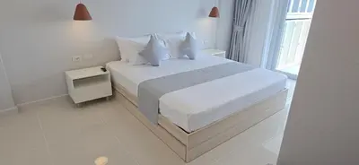 a white bedroom with a bed with white sheets and pillows at Babylon Sky Garden 2 in Rawai Beach