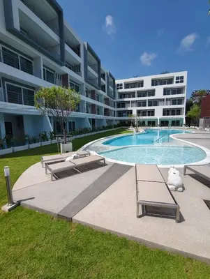 a large apartment building with a swimming pool and two benches at Babylon Sky Garden 2 in Rawai Beach
