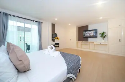 a bedroom with a large white bed with a television at Patong Center lucky home in Patong Beach