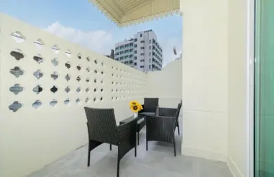 a table and chairs in a room with a wall at Patong Center lucky home in Patong Beach