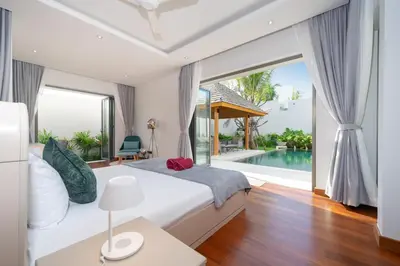 a bedroom with a bed and a pool at Thai-Balinese Pool Villa Anchan Indigo16 in Ban Phru Champa