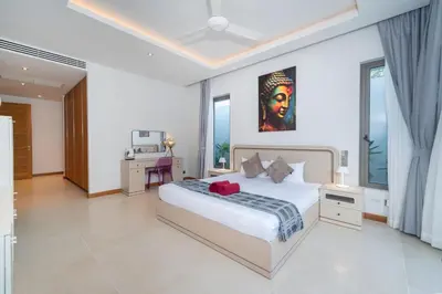 a bedroom with a bed and a desk in it at Thai-Balinese Pool Villa Anchan Indigo16 in Ban Phru Champa