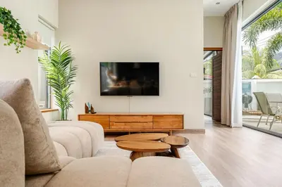 a living room with a couch and a tv at Baan Araya by Villacarte in Ban Saiyuan (1)