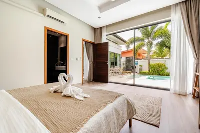 a bedroom with a bed with a white animal on it at Baan Araya by Villacarte in Ban Saiyuan (1)