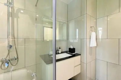 a white bathroom with a shower and a sink at Bangtao The Title Legendary by Phuket Sabay Rent F201 in Bang Tao Beach