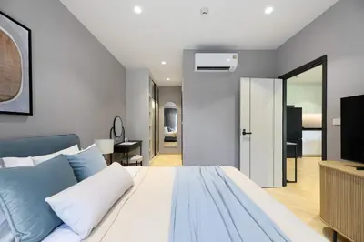 a bedroom with a white bed and a television at Bangtao The Title Legendary by Phuket Sabay Rent A212 in Bang Tao Beach