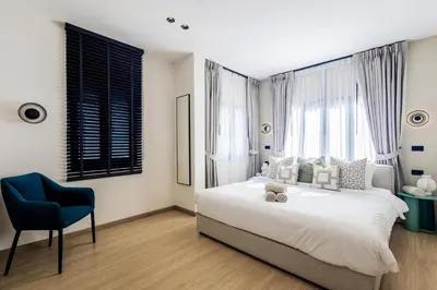 a bedroom with a large bed and a blue chair at 5BR Luxury Pool Villa Patong TPSV138 in Patong Beach
