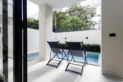 two chairs on the balcony of a house at 5BR Luxury Pool Villa Patong TPSV138 in Patong Beach