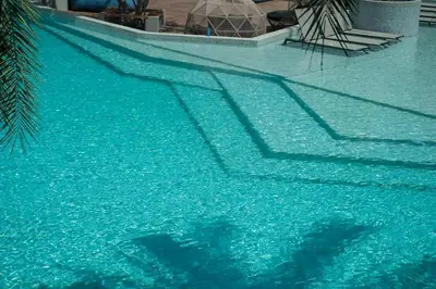 a pool of blue water with a palm tree in it at 2 BR Apt Pool View - CTG B507-8 in Kamala Beach