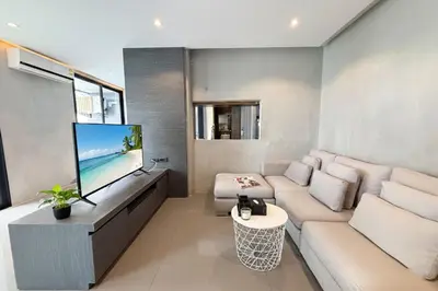 a living room with a couch and a flat screen tv at 2 BR Apt Pool View - CTG B507-8 in Kamala Beach