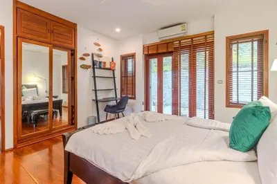 a bedroom with a large bed and a desk at V89 6BR Timeless Design Huge Pool & Mountain View in Rawai Beach