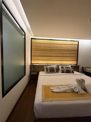 a bedroom with two beds and a large window at The Beach Condotel Kata in Kata Beach