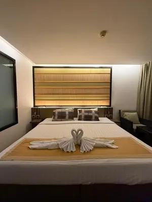 a bedroom with a bed with two white towels on it at The Beach Condotel Kata in Kata Beach
