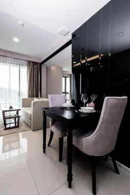 a dining room with a black table and chairs at Mida Grande Ocean View in Surin Beach
