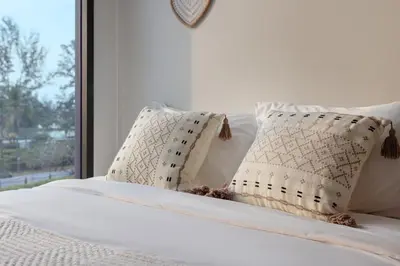 a bed with white sheets and pillows and a window at Melia 2BR with Rooftop Pool - Skypark Laguna in Laguna Phuket