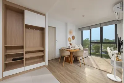 a kitchen and dining room with a table and chairs at Melia 2BR with Rooftop Pool - Skypark Laguna in Laguna Phuket