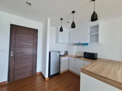 a kitchen with a refrigerator and a wooden door at BP Sweet Home Bang Tao - 607 in Ban Thalat Choeng Thale