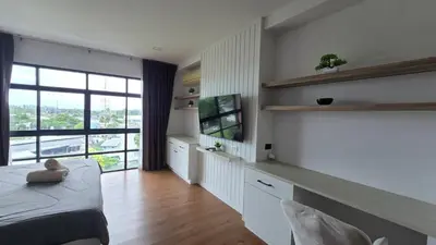 a bedroom with a bed and a large window at BP Sweet Home Bang Tao - 607 in Ban Thalat Choeng Thale