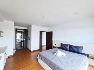 a bedroom with a large bed with blue pillows at BP Sweet Home Bang Tao - 607 in Ban Thalat Choeng Thale
