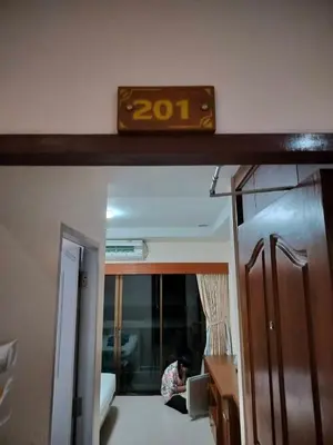a person sitting in a room with a clock on the wall at Hua LaiDe patong \u4e00\u5367\u5ba4\u5927\u5e8a\u623f in Patong Beach