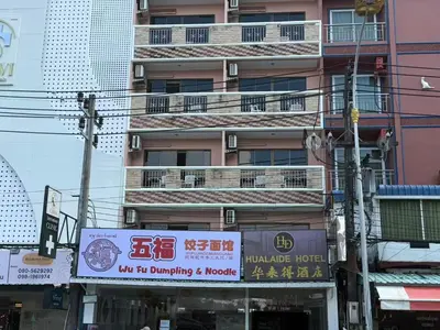 a tall pink building with a sign in front of it at Hua LaiDe patong \u4e00\u5367\u5ba4\u5927\u5e8a\u623f in Patong Beach