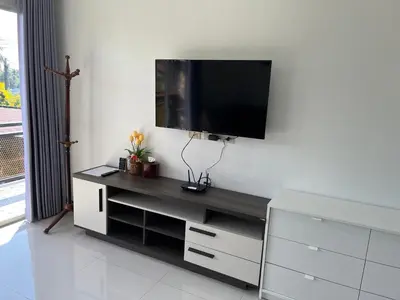 a living room with a tv on a wall at 365 Place Maikhao in Ban Mai Salae