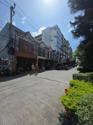 two people walking down a street in front of buildings at Tower2 Condominium in Ban Klang