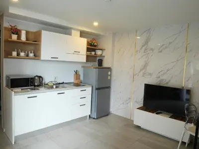 a kitchen with white cabinets and a refrigerator at Tower2 Condominium in Ban Klang