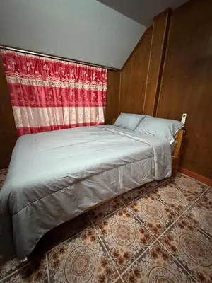 a bed in a room with a red curtain at Family house in Ban Laem Sai
