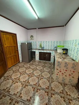 a kitchen with a refrigerator and a tile floor at Family house in Ban Laem Sai