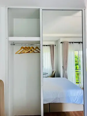 a bedroom with a white bed and a mirror at Sarona House 4 in Ban Thalat Choeng Thale