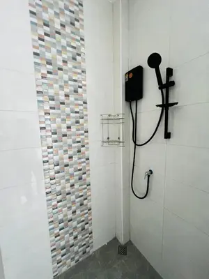 a bathroom with a shower with a phone on the wall at Sarona House 4 in Ban Thalat Choeng Thale