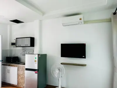 a kitchen with a refrigerator and a tv on the wall at Sarona House 4 in Ban Thalat Choeng Thale