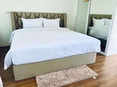 a large bed in a bedroom with a mirror at Sarona House 4 in Ban Thalat Choeng Thale