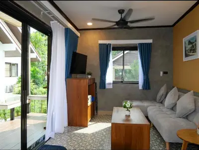 a living room with a couch and a tv at Baan Ati Villas in Ban Han Pa To