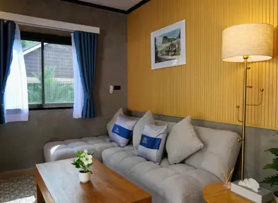 a living room with a couch with pillows on it at Baan Ati Villas in Ban Han Pa To