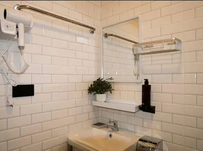 a white tiled bathroom with a sink and a mirror at Baan Ati Villas in Ban Han Pa To