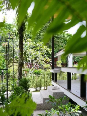 a house in the middle of a garden with trees at Baan Ati Villas in Ban Han Pa To