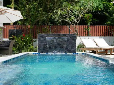 a swimming pool with a fire place in a backyard at Baan Ati Villas in Ban Han Pa To