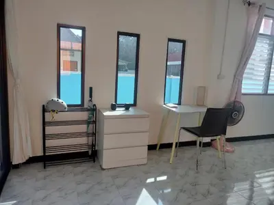 a room with a desk and a chair and windows at Soi Saliga in Rawai Beach