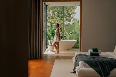 a woman standing in a bathroom looking out the window at Botanica Foresta B09 in Ban Phru Champa