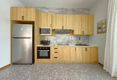 a kitchen with wooden cabinets and a white refrigerator at Bangtao Luxury Pool Villa - PrymaSelva in Laguna Phuket