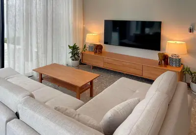 a living room with a couch and a tv at Bangtao Luxury Pool Villa - PrymaSelva in Laguna Phuket