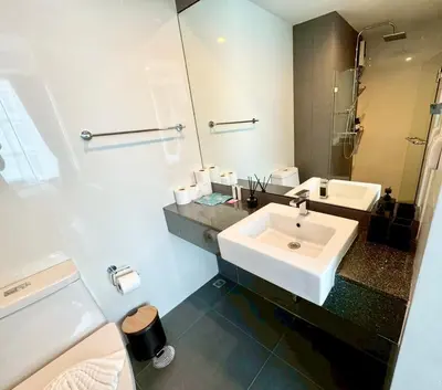 a white bathroom with a sink and a mirror at Stylish 1BR Surin Beach Kitchen & Rooftop Pool by Renttini in Ban Lum Fuang