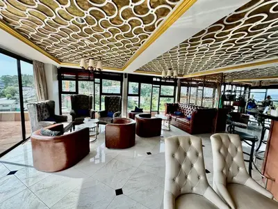 a lobby with couches and tables and windows at Stylish 1BR Surin Beach Kitchen & Rooftop Pool by Renttini in Ban Lum Fuang
