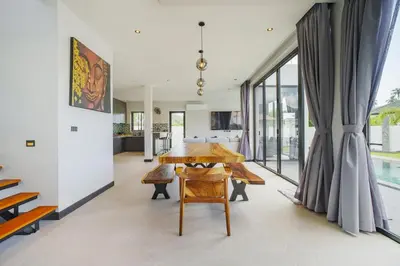 a kitchen and dining room with a wooden table at Camellia Pool VillaNear Nai Harn And Rawai Beach in Ban Saiyuan (1)