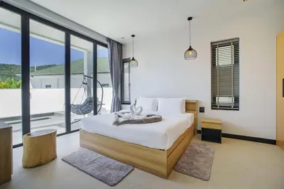 a bedroom with a bed and a large window at Camellia Pool VillaNear Nai Harn And Rawai Beach in Ban Saiyuan (1)
