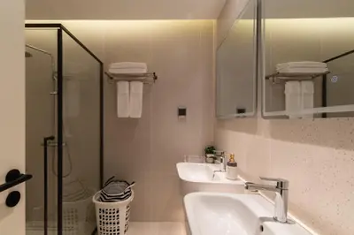 a bathroom with a sink and a shower and a mirror at Sunshine Beach Appartments, 2BD in Layan Beach