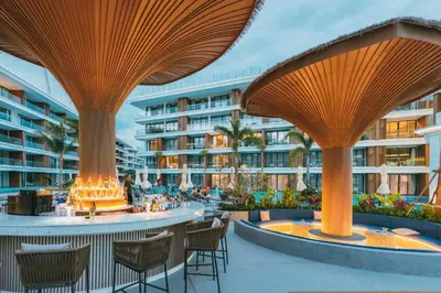 a resort with tables and chairs and a building at Sunshine Beach Appartments, 2BD in Layan Beach